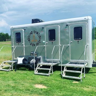 three stall portable restroom on grass