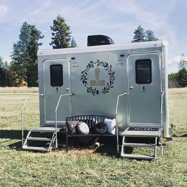 two stall portable restroom on grass