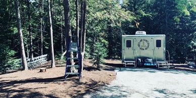 portable restroom trailer in a wooded area