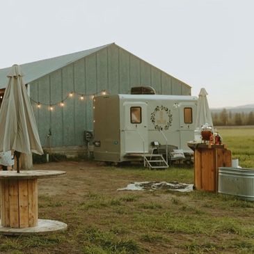 sepia tone view of a trailer in front of a barn in a rustic setting event