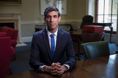 Man in a suit seated at a table in an office.