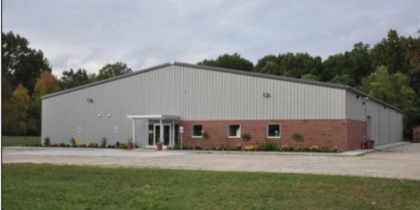 A large industrial building with a metal roof and brick facade.