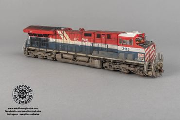 Detailed model train locomotive in red, white, and blue colors.