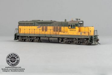 Yellow and green model train locomotive on a plain background.
