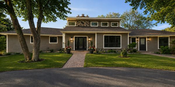 A modern single-story house with a brick pathway and well-maintained lawn.