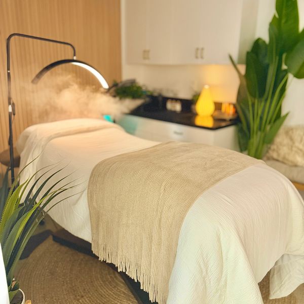A cozy massage or spa table with soft lighting and plants.