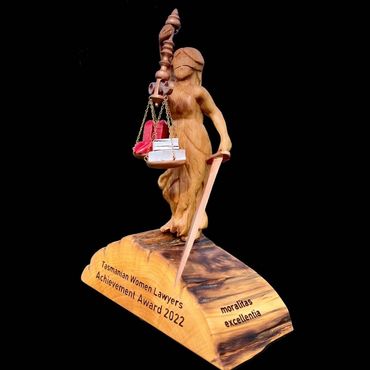 A custom designed and hand carved award featuring Lady Justice, with traditional and unique features