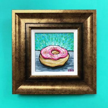Framed painting of a pink-frosted donut with sprinkles on a turquoise background.