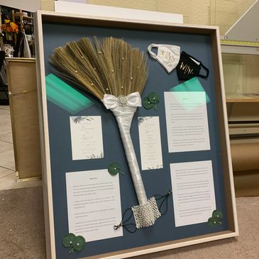 Wedding memory shadow box with bouquet, masks, and vows.