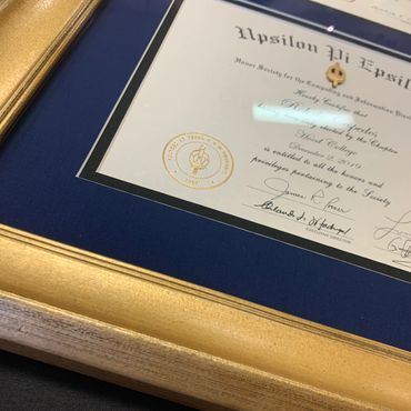 Framed Upsilon Pi Epsilon honor society certificate with gold seal and pin.