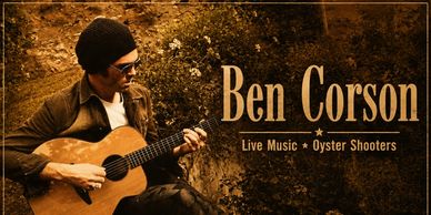 Ben Corson playing acoustic guitar in a sepia-toned image.