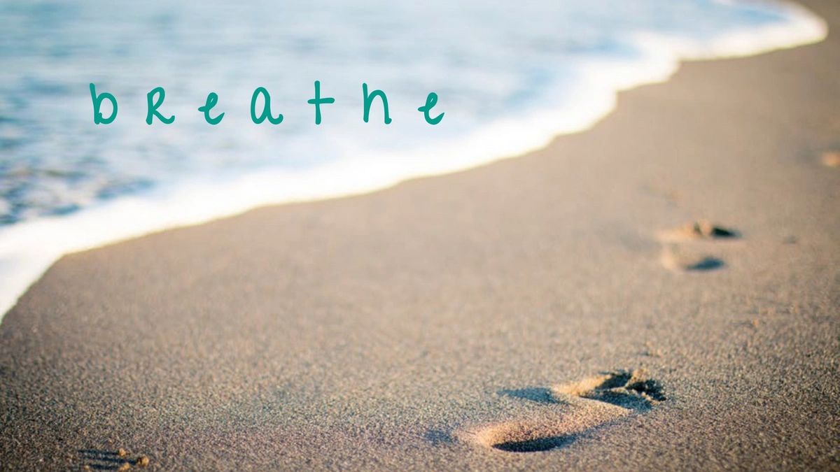Footprints on a sandy beach with the word 'breathe'.
