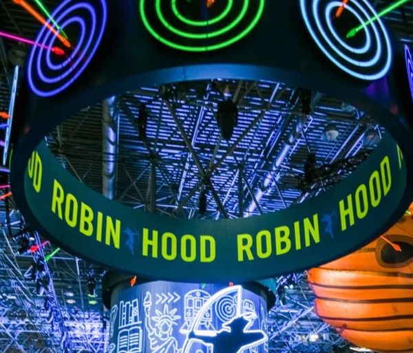 Neon sign with the text "ROBIN HOOD" at an indoor venue.
