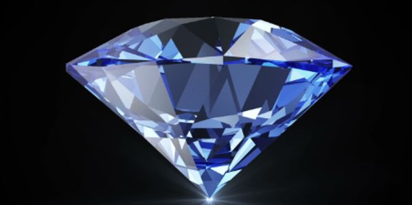 A sparkling blue diamond shining against a black background.