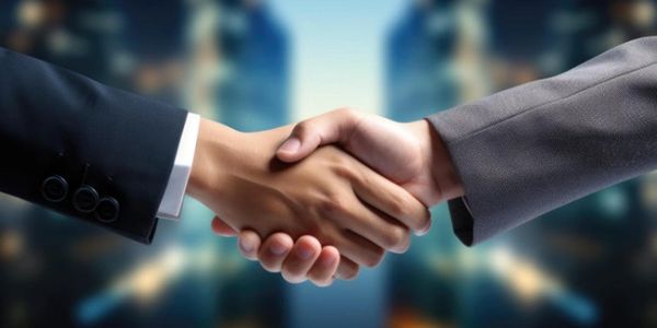 Close-up of two people shaking hands in a business setting.