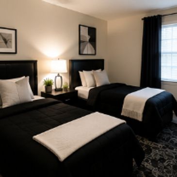 Modern bedroom with two beds and black bedding.