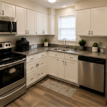 Modern kitchen with white cabinets and stainless steel appliances.