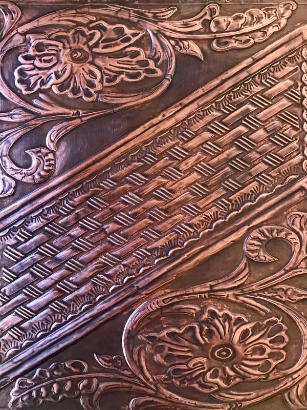 A beautiful copper work with flower pattern on a white background