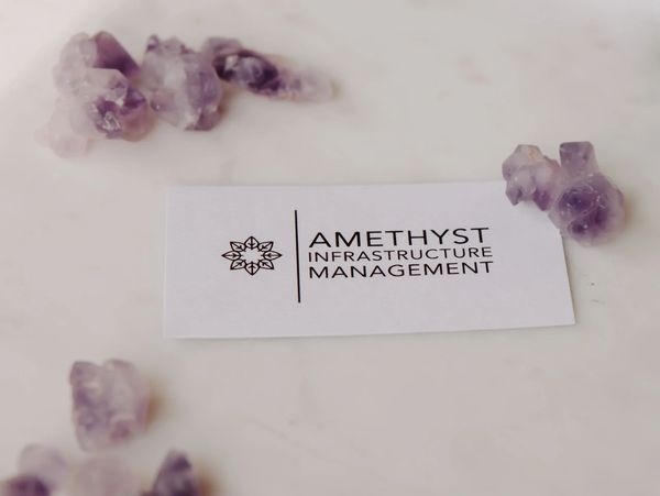 Amethyst stones in small groups around a business card that says Amethyst Infrastructure Management