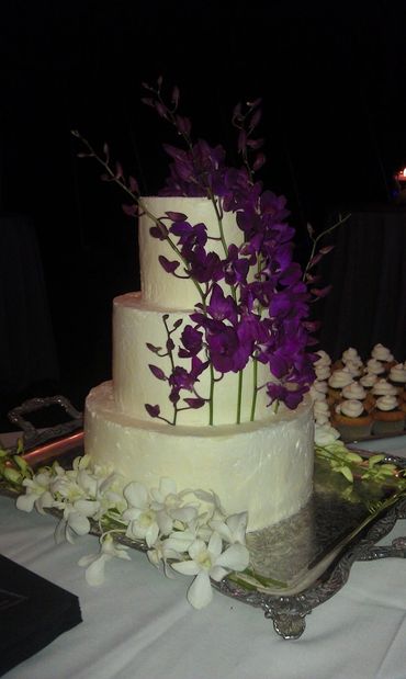 A three-layer cake with purple flowers