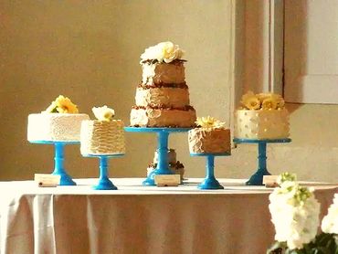 A three-tiered cakes with one-tiered cakes on a cake stand