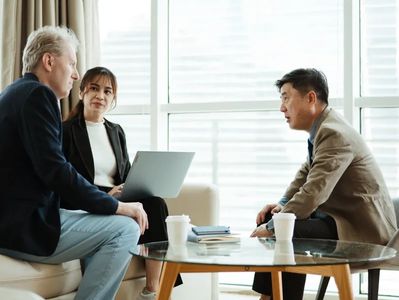 Tres personas en una reunión de negocios en una oficina.