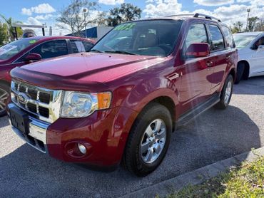 Shiny red Ford SUV parked outdoors under a partly cloudy sky.