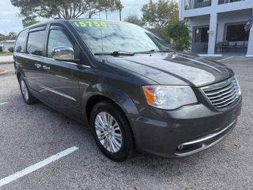 Dark gray minivan parked with a $5750 price tag on the windshield.