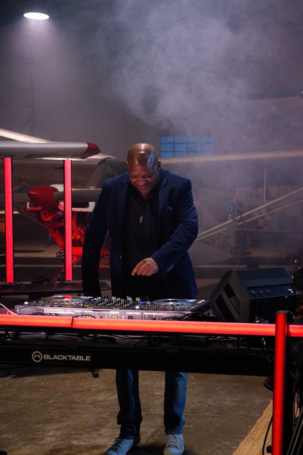 DJ playing music and looking at his equipment, you can see he is enjoying himself