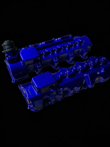 A photo of two blue headers that were Powder coated by powder coating it St. Louis