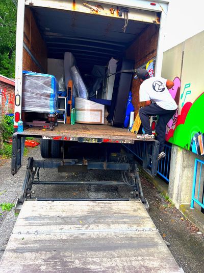 Person jumping into a truck loaded with furniture.