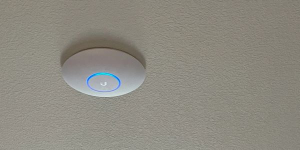 Ubiquiti access point securely mounted on the ceiling, providing network access to users