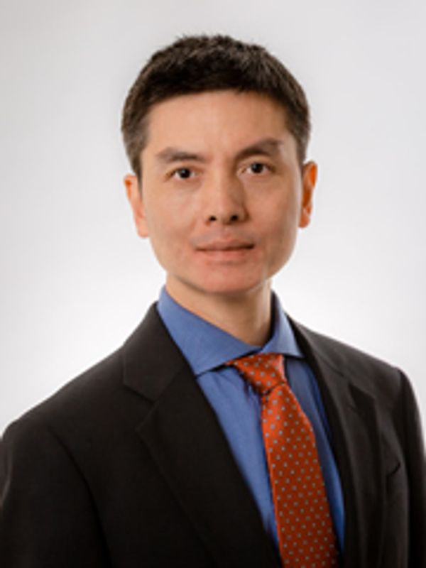 Professional man in suit and red tie against white background.