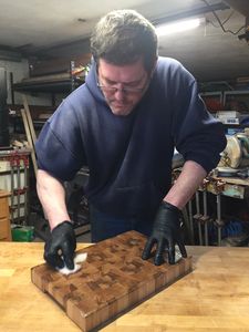 Vin putting the final protective coating on a Maple, end-grain cutting board.
