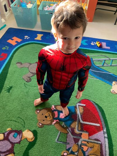 A young child dressed as Spiderman for playtime at daycare