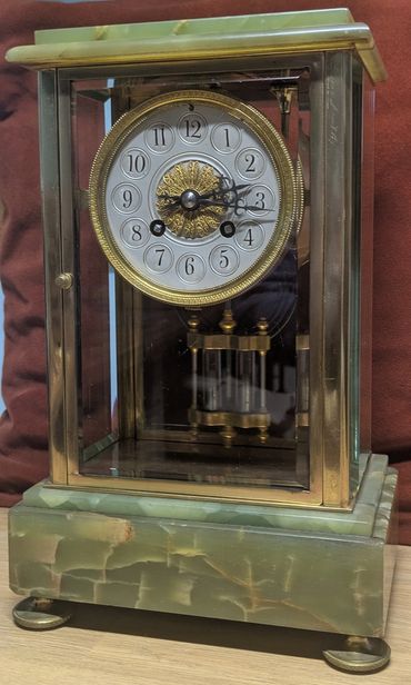 Antique mantel clock with glass panels and green marble base.