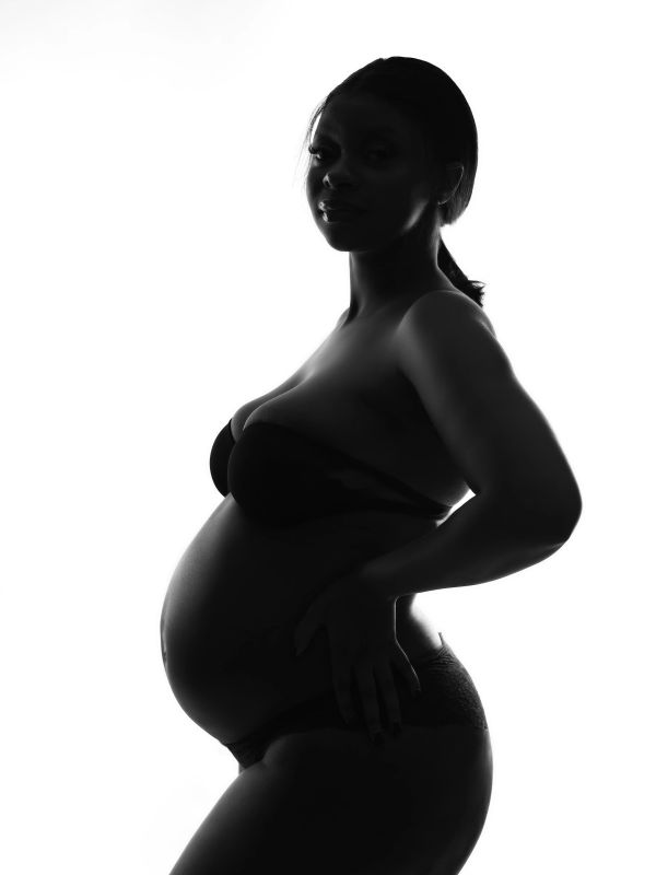 Silhouette of a pregnant woman in lingerie.