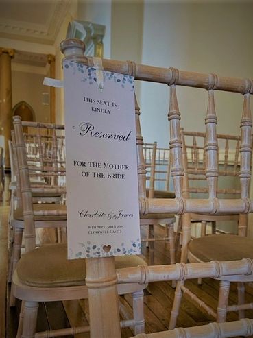 Reserved seating sign hanging on a wooden chair in a wedding ceremony room