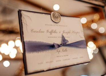 Wedding Table/Seating Plan card, with blue backing and ribbon, mounted on a mirror with a wax seal.