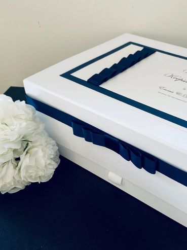 White Wedding Keepsake Box, with white & navy blue label and navy blue ribbons and bow.
