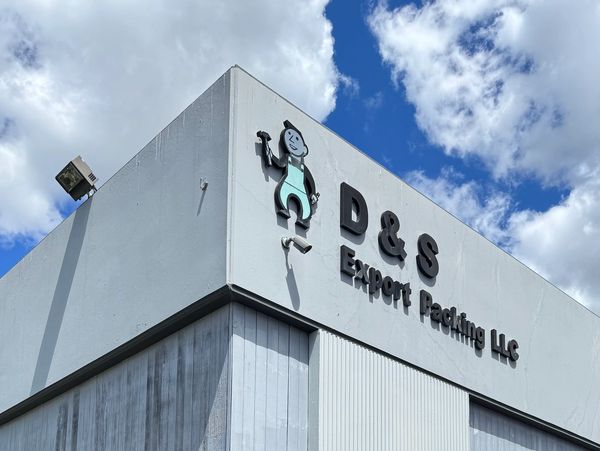 Exterior of D & S Export Packing LLC building under a blue sky.