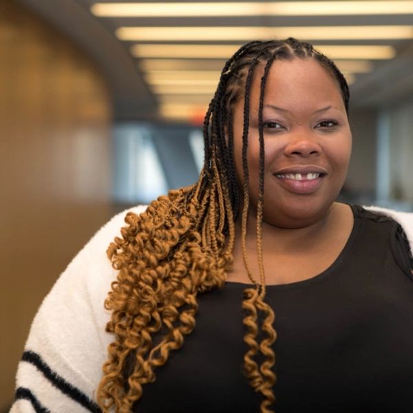 headshot of black woman with braids in gradient from dark brown to lighter brown