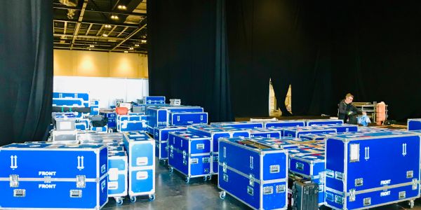 Large number of blue equipment cases in a storage space.