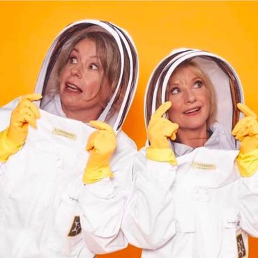 Esther and her best friend Jane Horrocks wearing bee suits with yellow rubber gloves