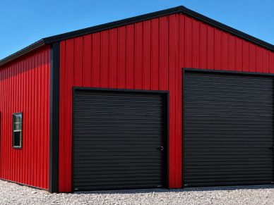 Red barn with two black garage doors.