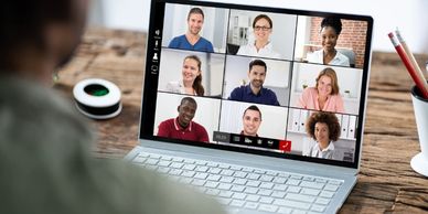 Person attending a virtual meeting with nine participants on a laptop.