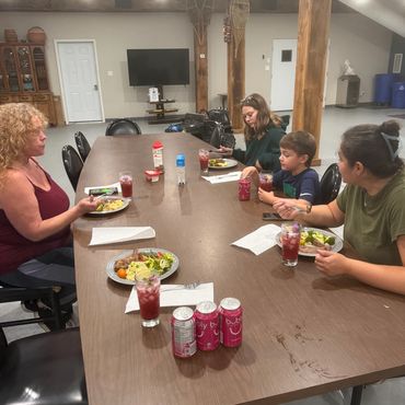 Workshop participants seated around a table sharing food and learning together.
