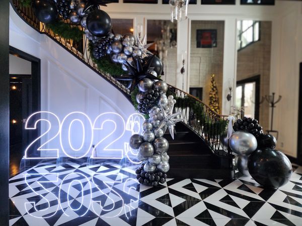 Black and silver luxury balloon garland on staircase with Led neon number sign New years eve ,NYE
