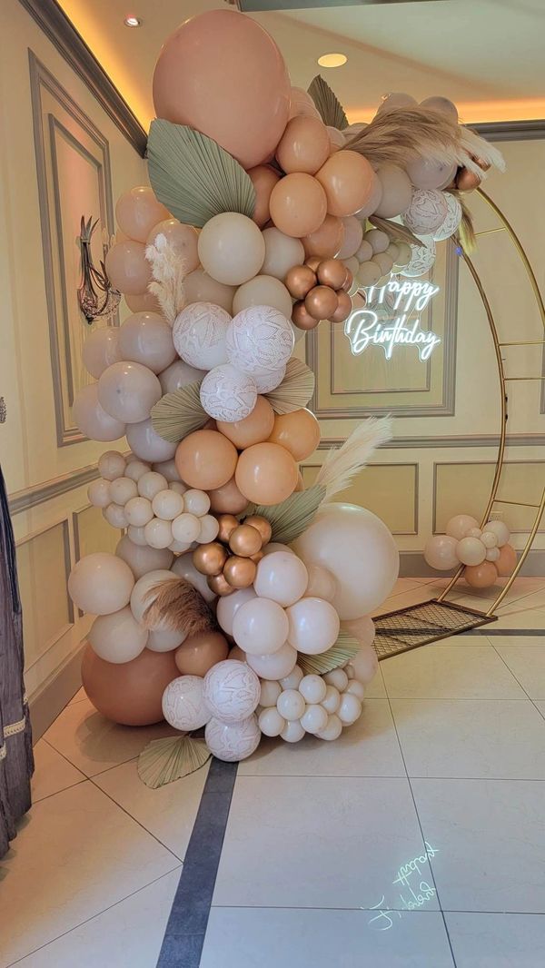 Natural color balloon with snake print on a gold moon gate arch for a birthday party