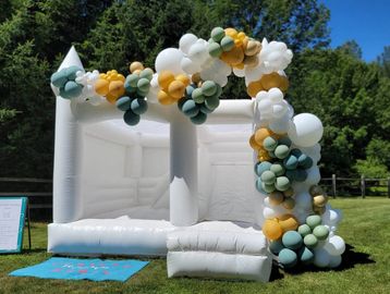 White bounce house, bounce castle with slide and balloon garland